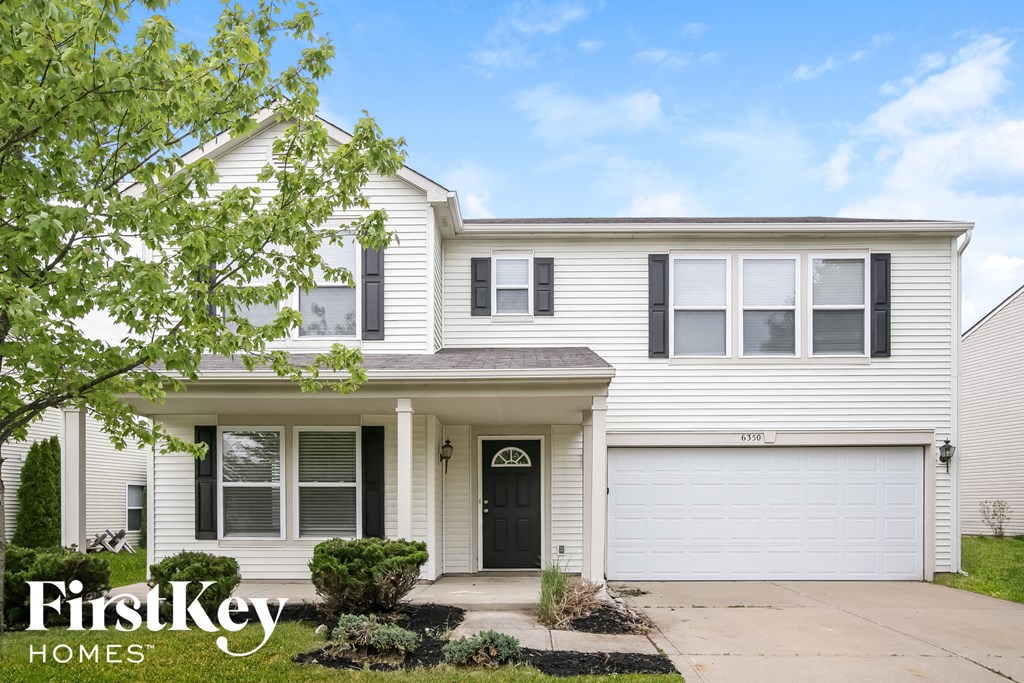 a white house with black shutters and a black door