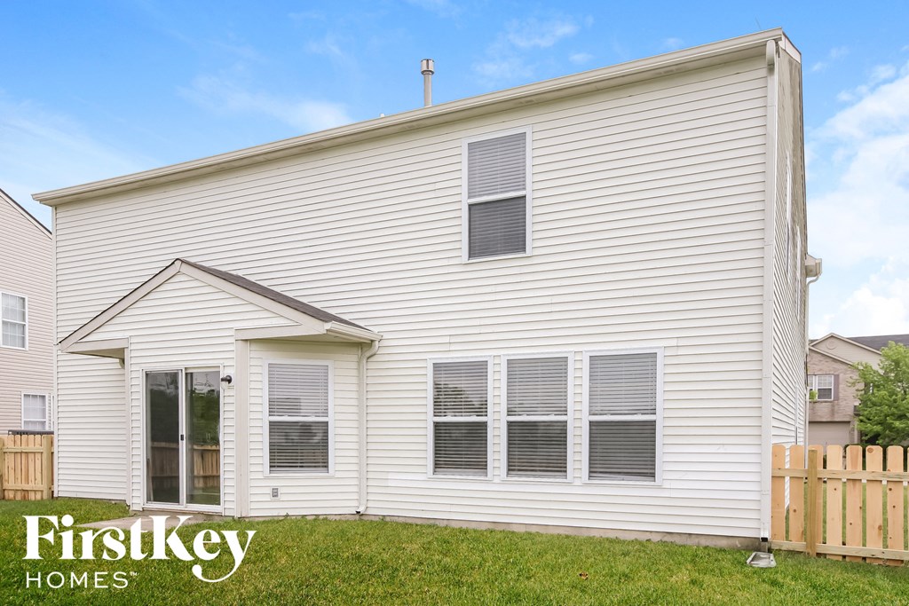 a white house with a yard and a wooden fence