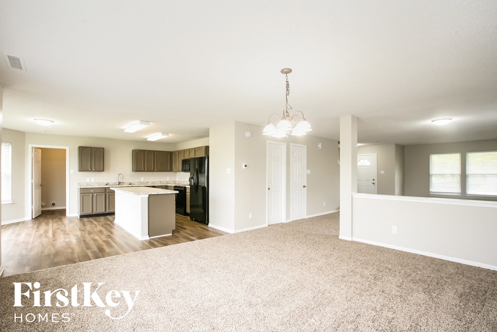 an open kitchen and living room with a carpeted floor