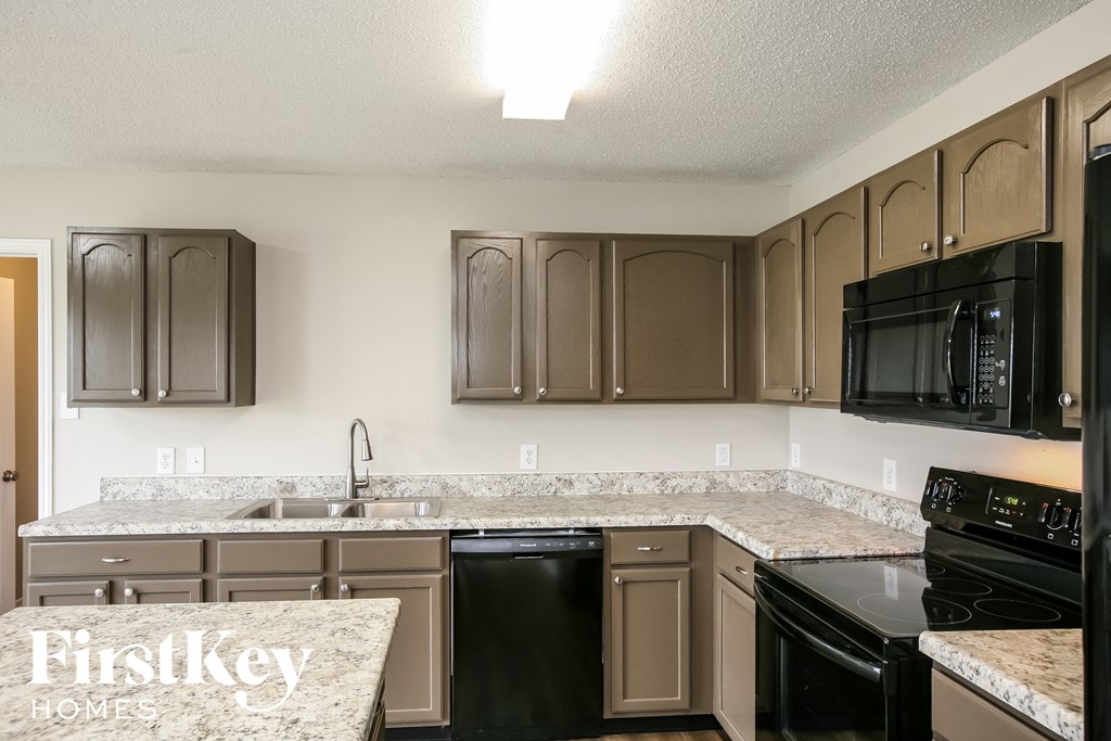 a kitchen with granite counter tops and black appliances
