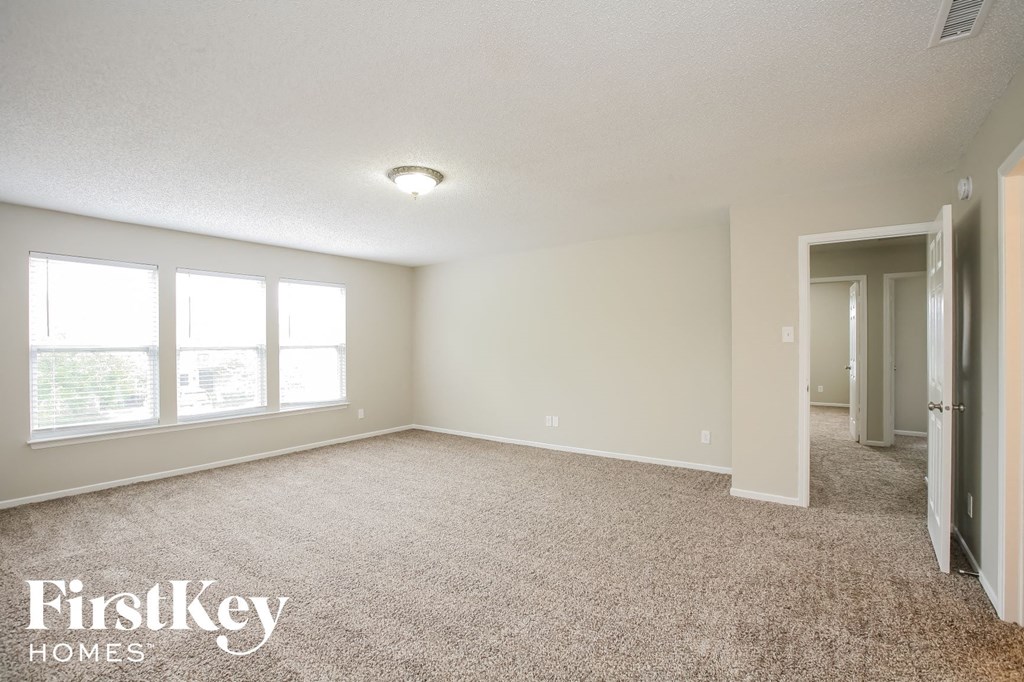 a master bedroom with carpeted flooring and a door to a closet