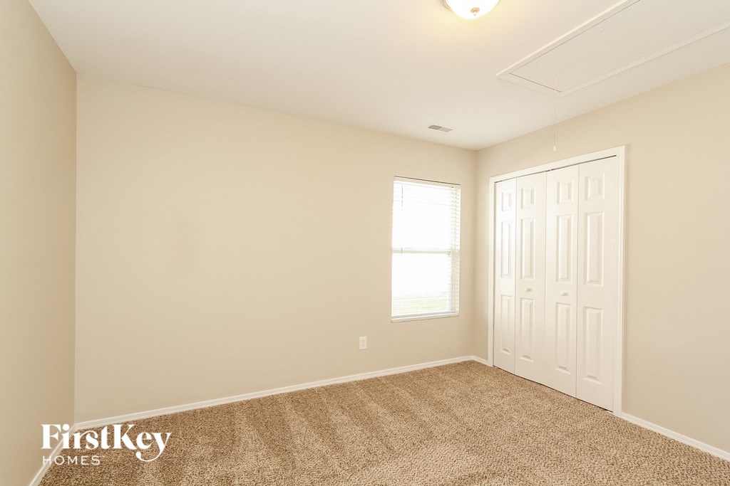 a bedroom with carpet and a white door and window