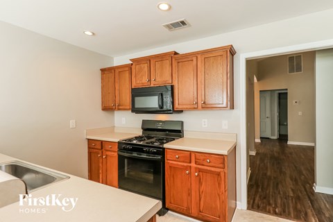 a kitchen with wooden cabinets and a stove and a microwave