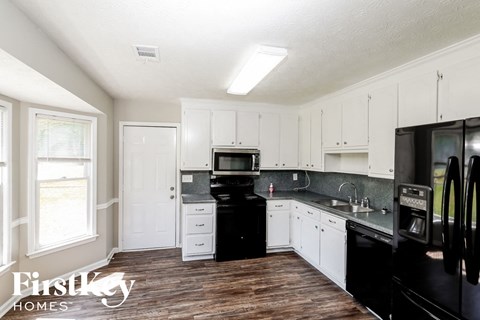 a kitchen with black appliances and white cabinets