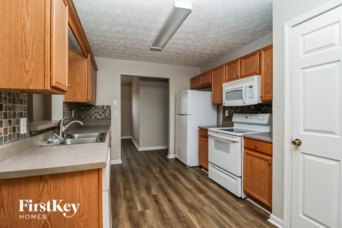 A kitchen with wooden cabinets and a white refrigerator.