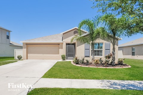 a beige house with a palm tree in the front