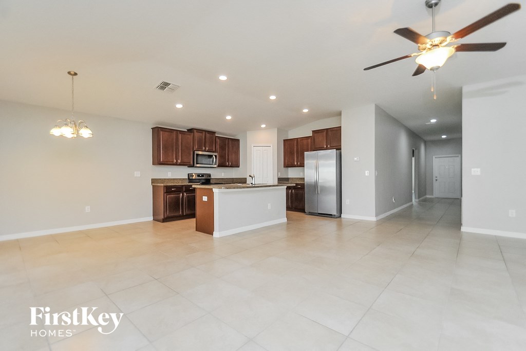 an open kitchen and living room with a ceiling fan
