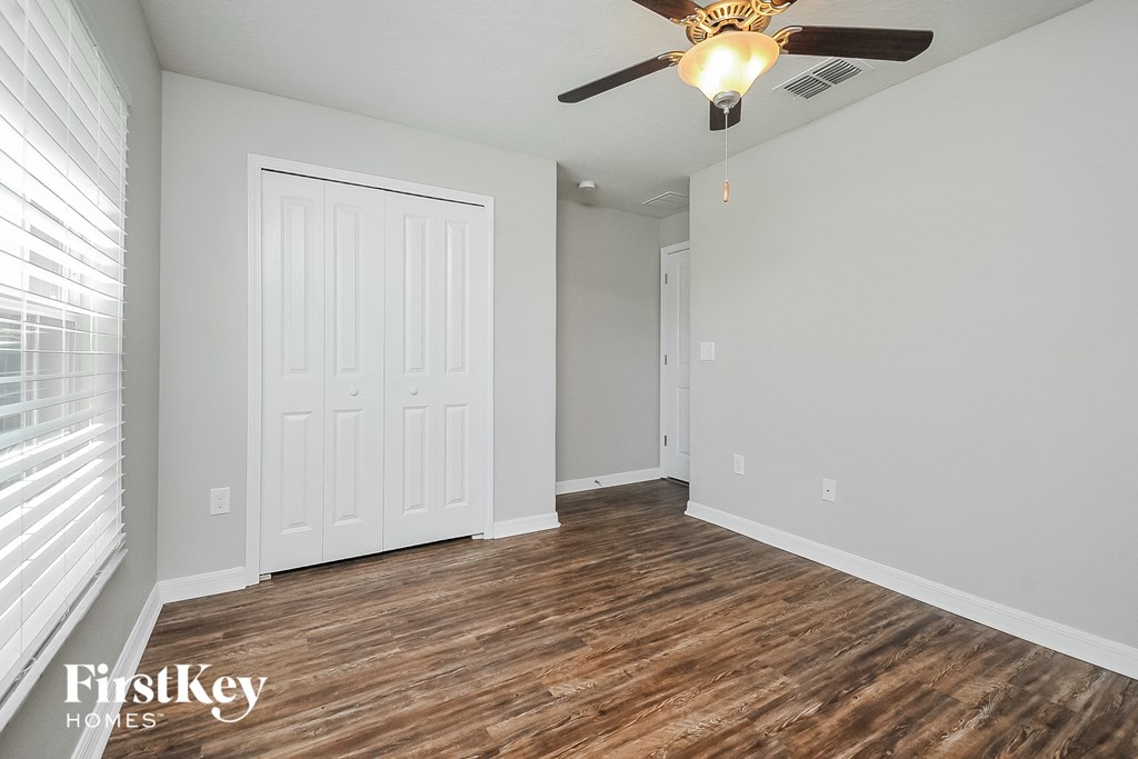 the living room of an empty house with a ceiling fan