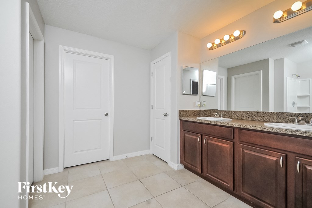 a master bathroom with two sinks and a large mirror