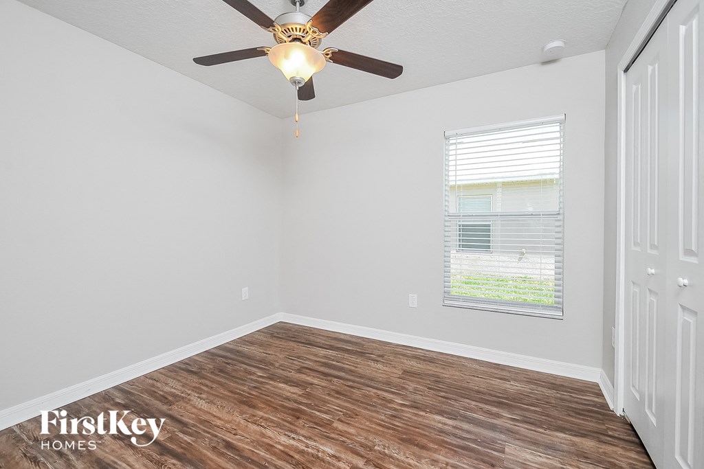 the living room of a home with wood flooring and a ceiling fan