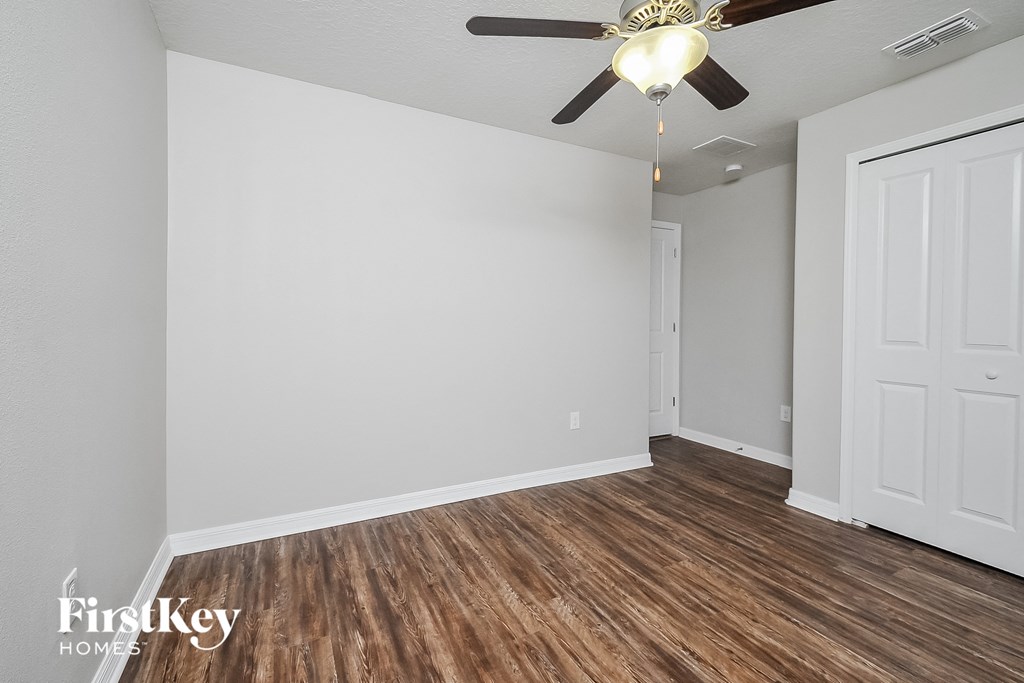 the living room of an empty house with a ceiling fan