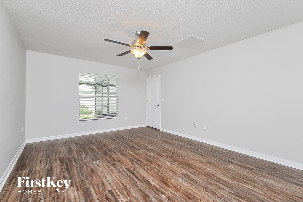 the living room of an empty house with a ceiling fan