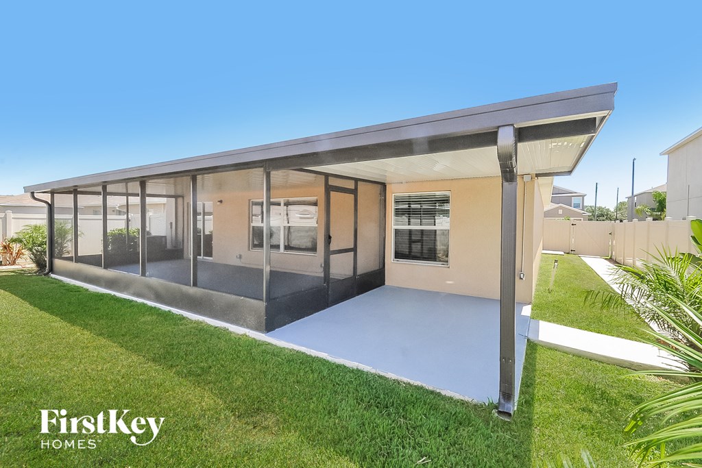 a modern house with a patio and a lawn