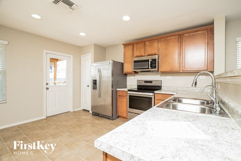 a large kitchen with stainless steel appliances and marble counter tops