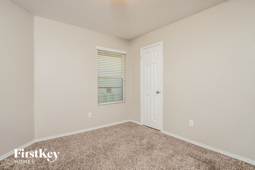 a bedroom with a white door and a window and carpet