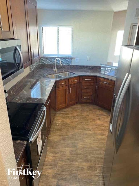 A kitchen with wooden cabinets and a black stove top oven.