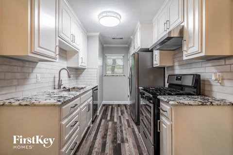 A kitchen with a black refrigerator and a black microwave.