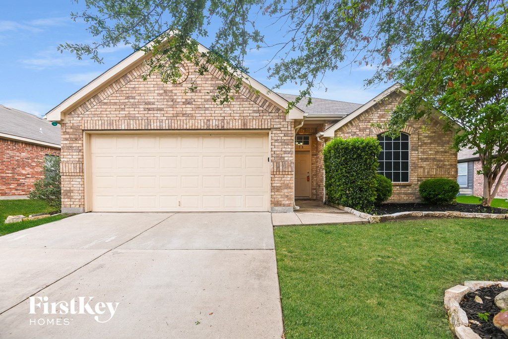a tan brick house with a white garage door