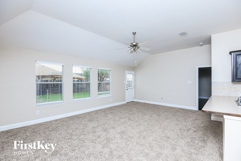 a living room with carpet and a ceiling fan