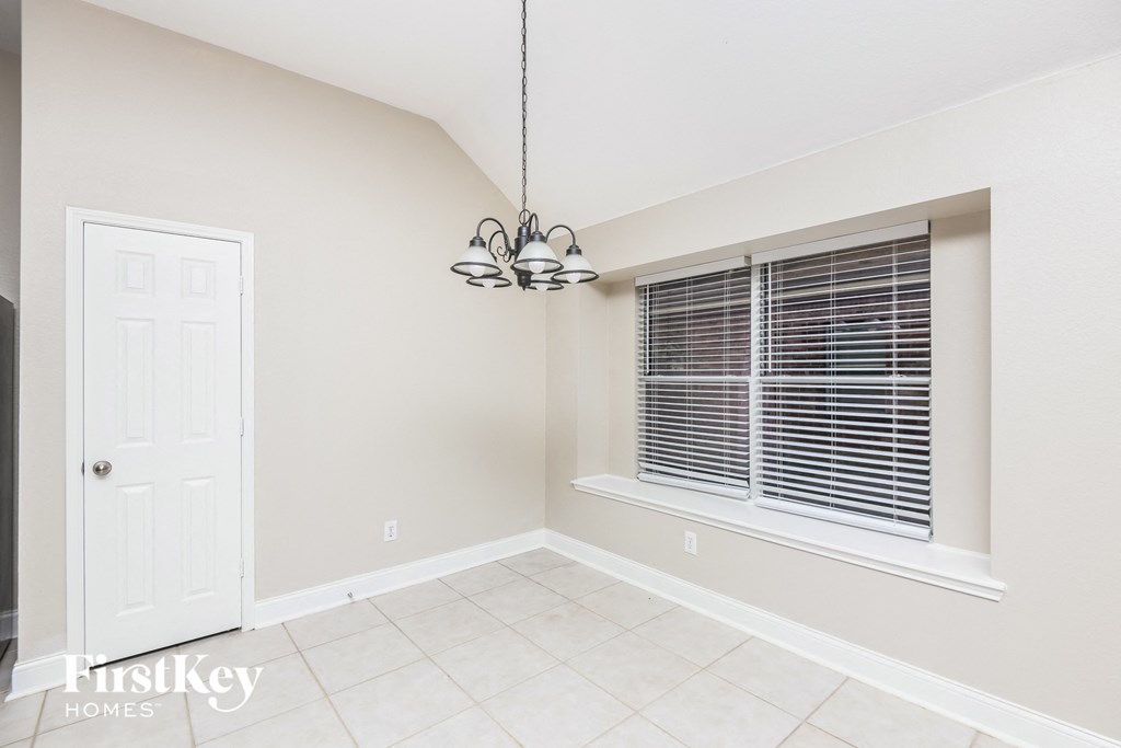 a dining room with a large window and a chandelier