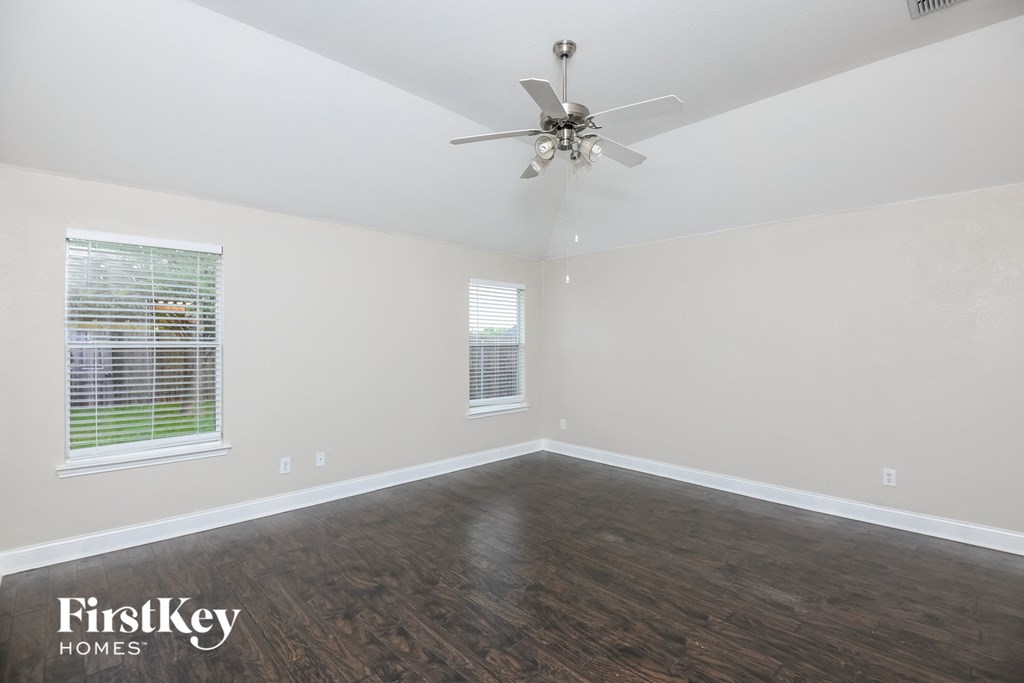 the living room of a home with wood flooring and a ceiling fan