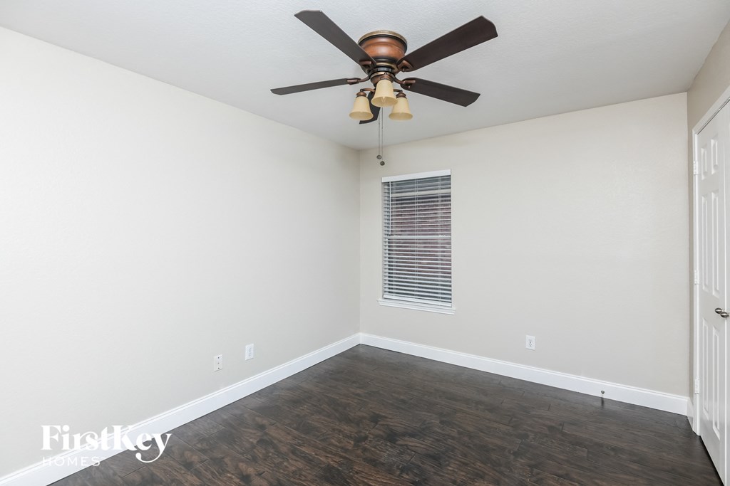 a living room with a ceiling fan and wooden floors