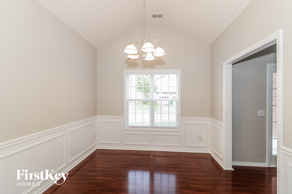 a dining room with white walls and a window
