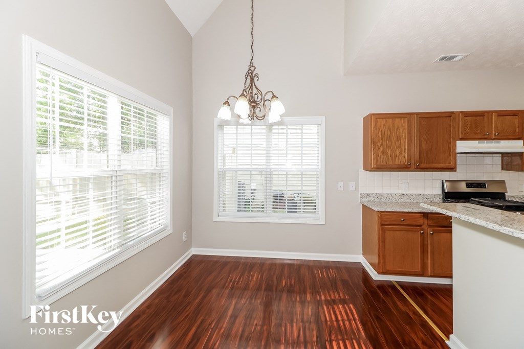 an empty kitchen with wood flooring and a large window
