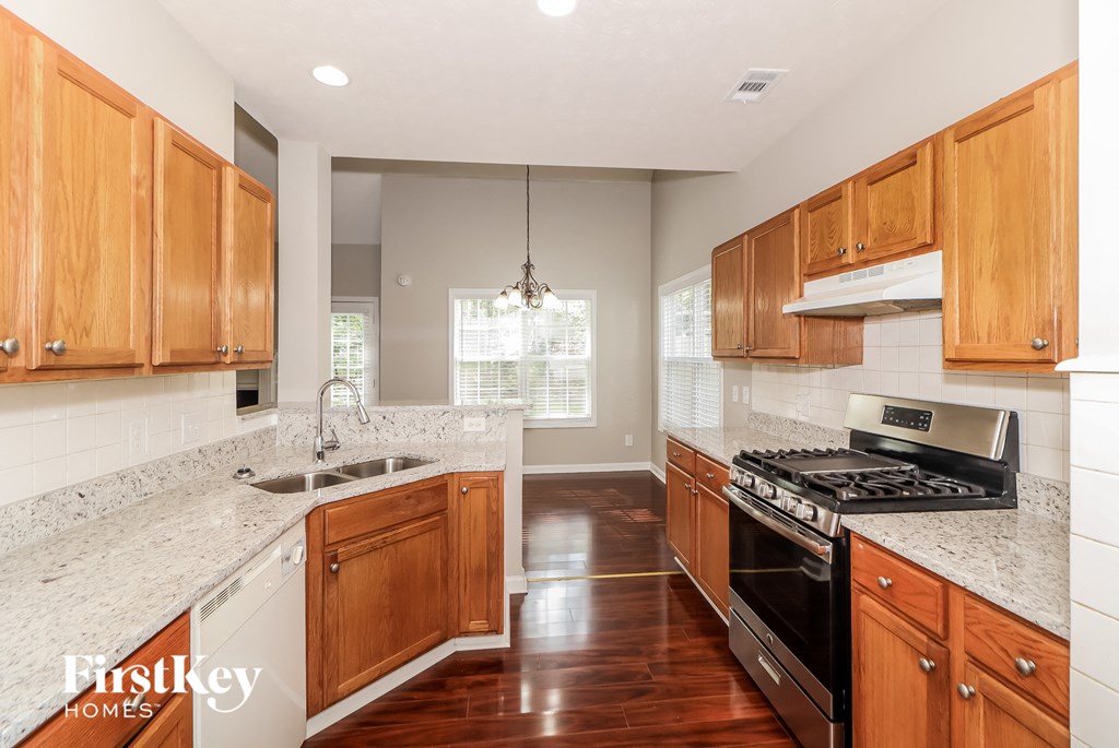 a kitchen with wooden cabinets and granite counter tops and a stove top oven