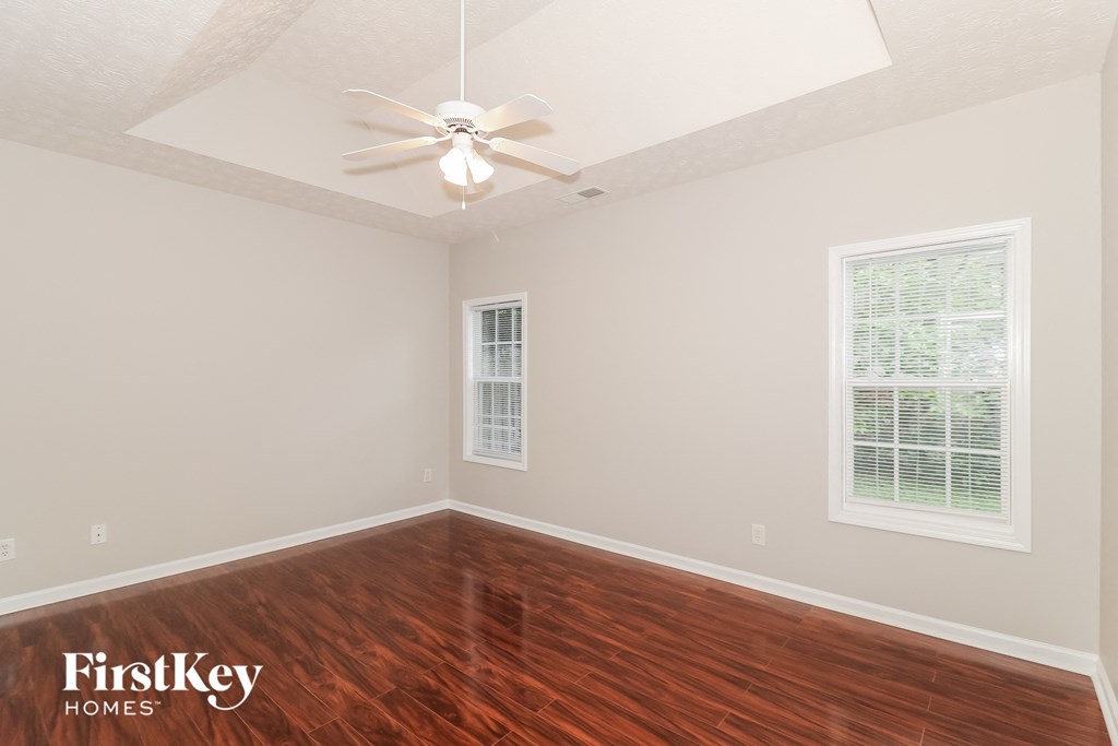 a bedroom with hardwood flooring and a ceiling fan