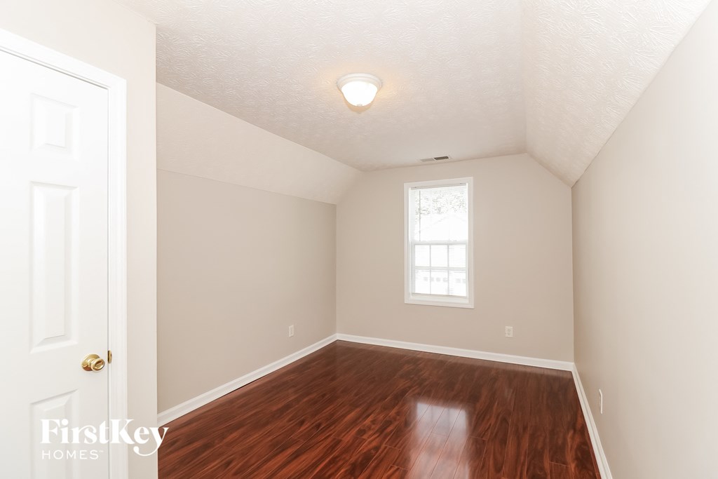 a bedroom with hardwood flooring and a window