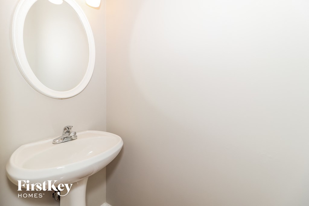 a white bathroom with a sink and a mirror