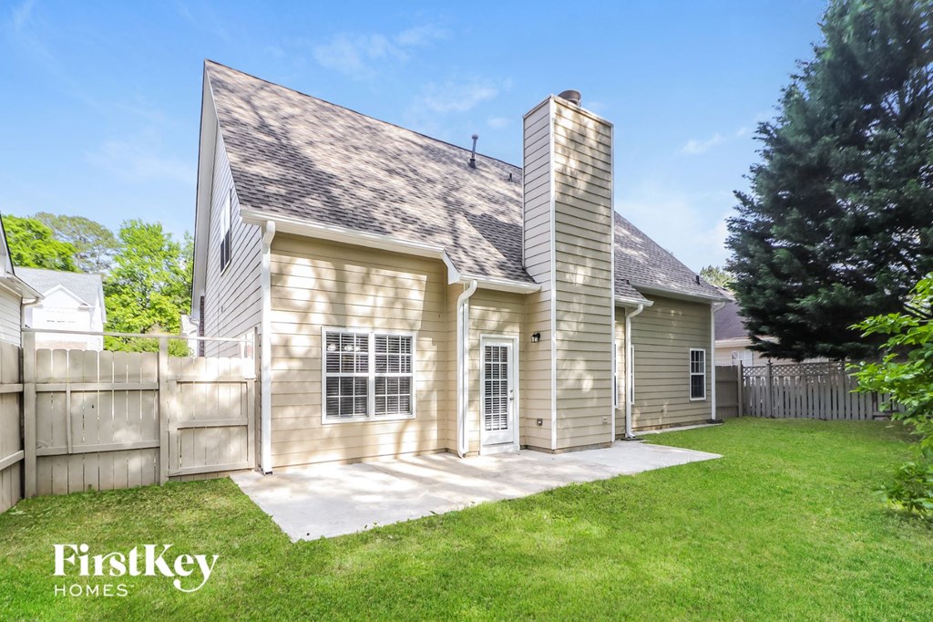 the outside of a house with a yard and a fence