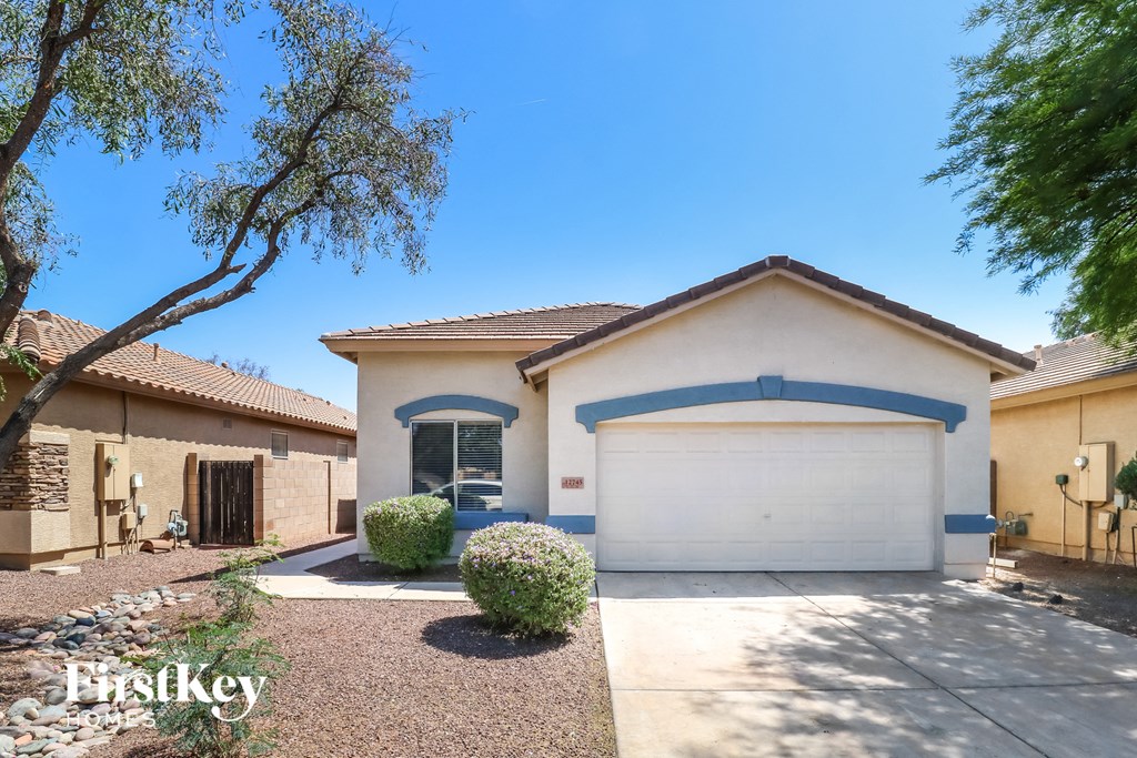 a house with a garage door and a tree