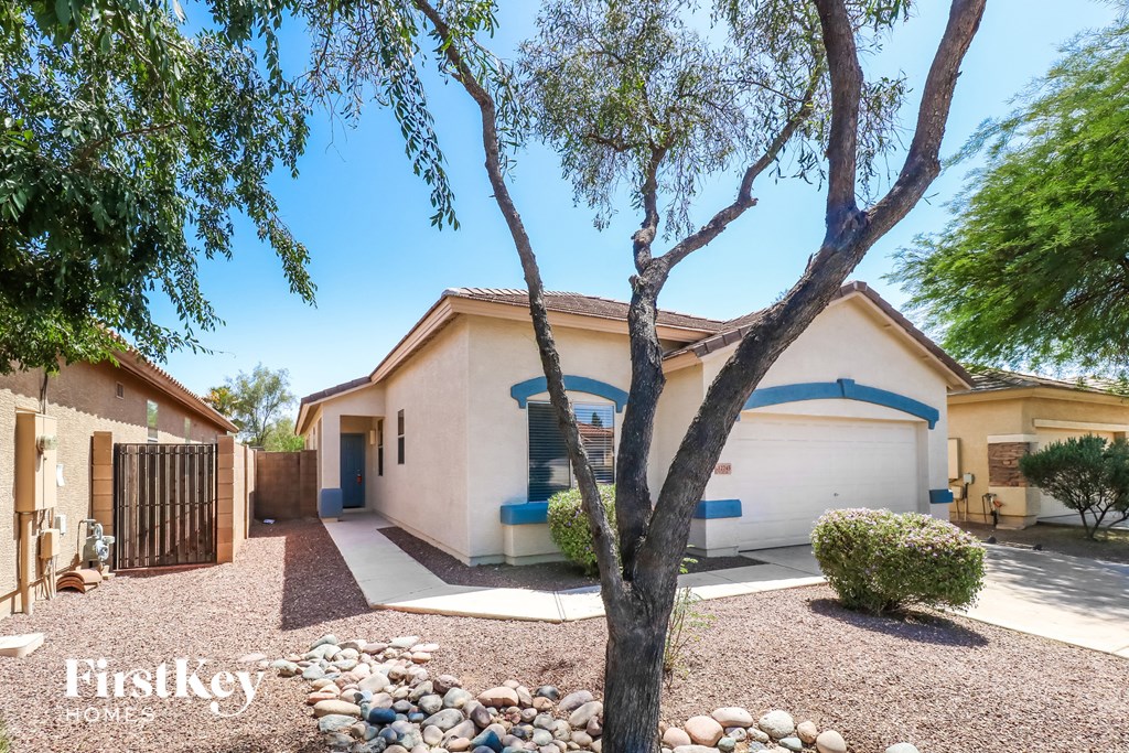 a home with a driveway and a tree in front of it