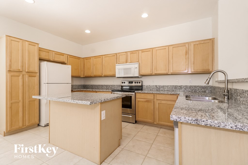 a kitchen with granite counter tops and wooden cabinets