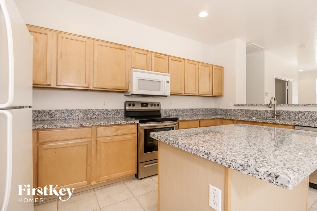 a kitchen with granite counter tops and wooden cabinets