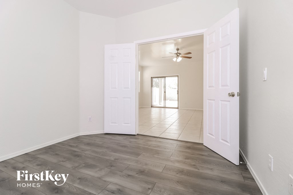 a living room with white walls and a white door opens to a large white room