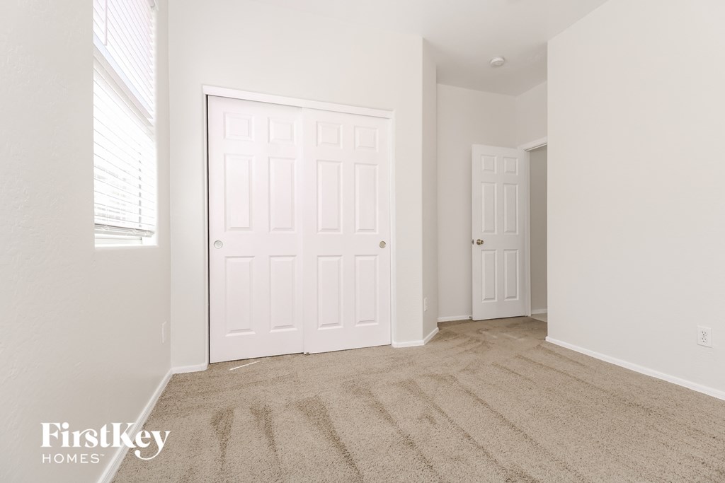 a bedroom with two closets and a carpeted floor