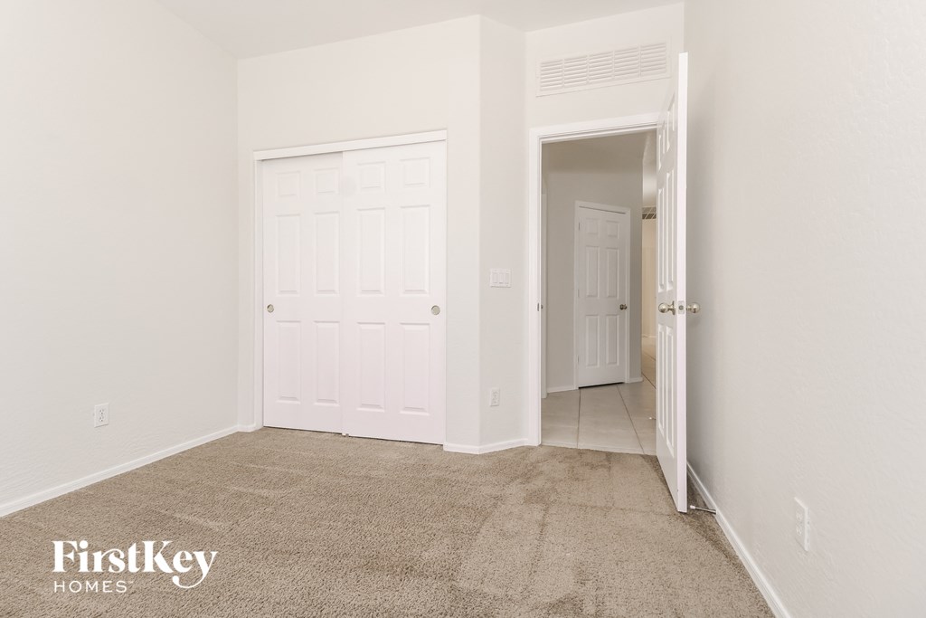 a bedroom with a carpeted floor and a white door