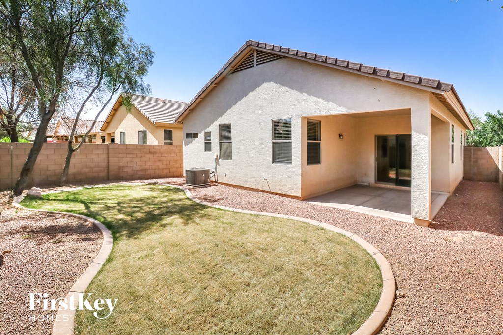 a small white house with a yard and a fence