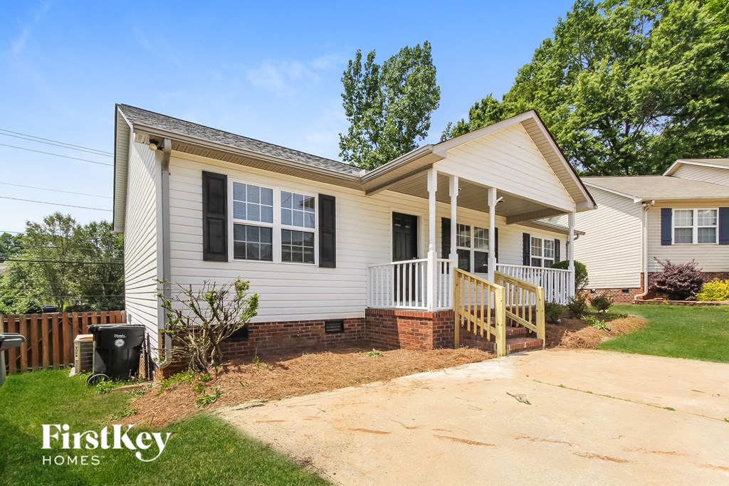a white house with a porch and a driveway