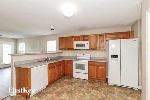 A kitchen with wooden cabinets and white appliances.