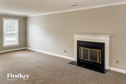 a living room with a fireplace and a carpeted floor