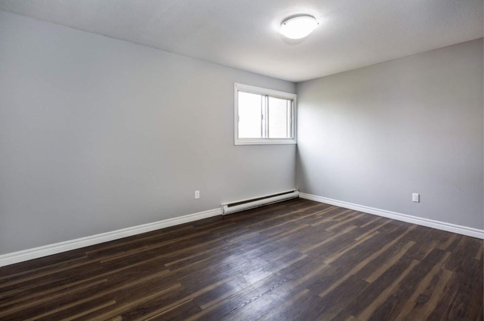 A room with wooden flooring and a window.