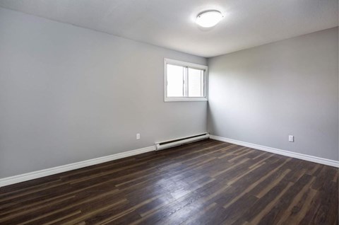 A room with wooden flooring and a window.