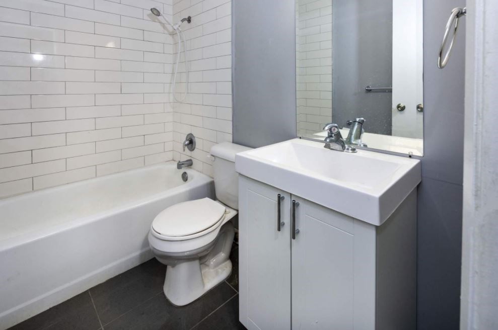 A white toilet sits next to a white sink in a bathroom.