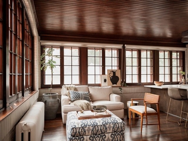 A living room with a white couch and a wooden chair.