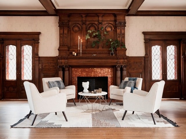 A living room with a fireplace and two chairs.