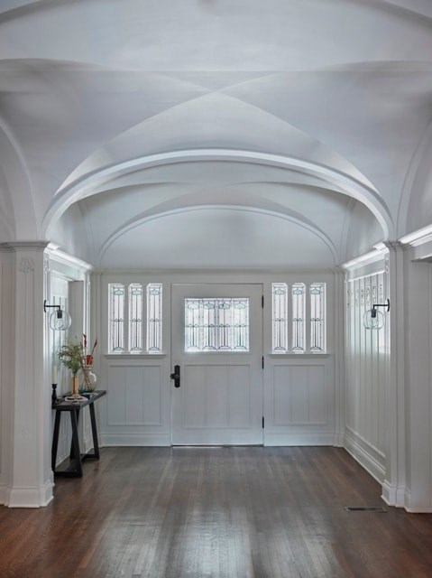 A white hallway with a table and a vase on it.